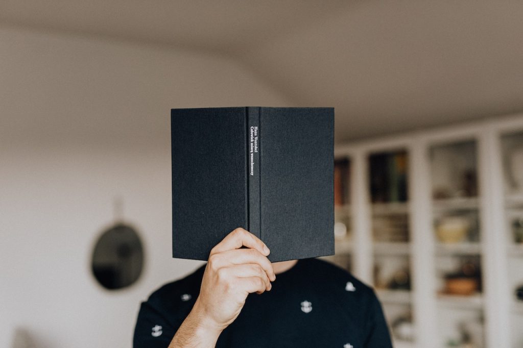 man holding a book - Marketing and Promotion for your Niche Course