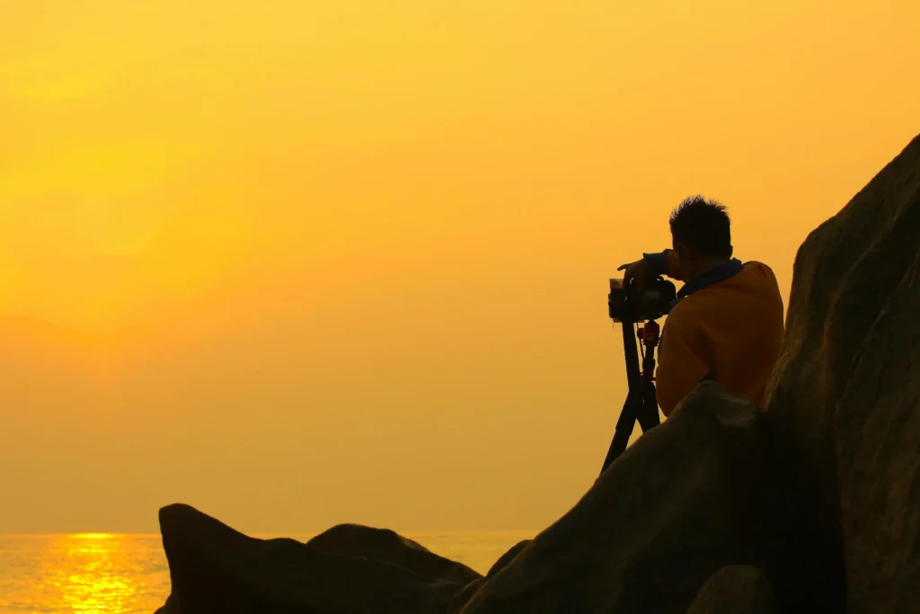 photographer capturing sunset on beach